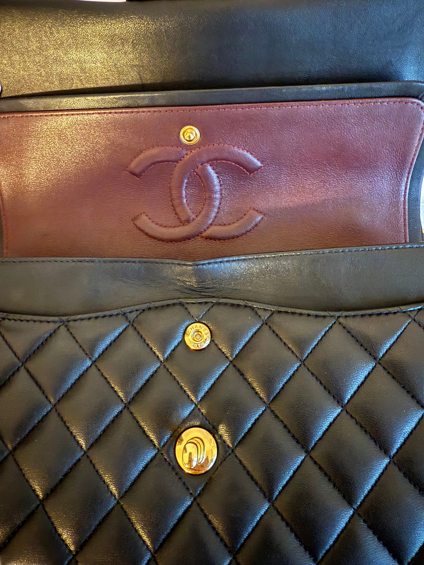 Bolsa Chanel Timeless Classic Flap em couro lambskin preto com ferragens douradas.